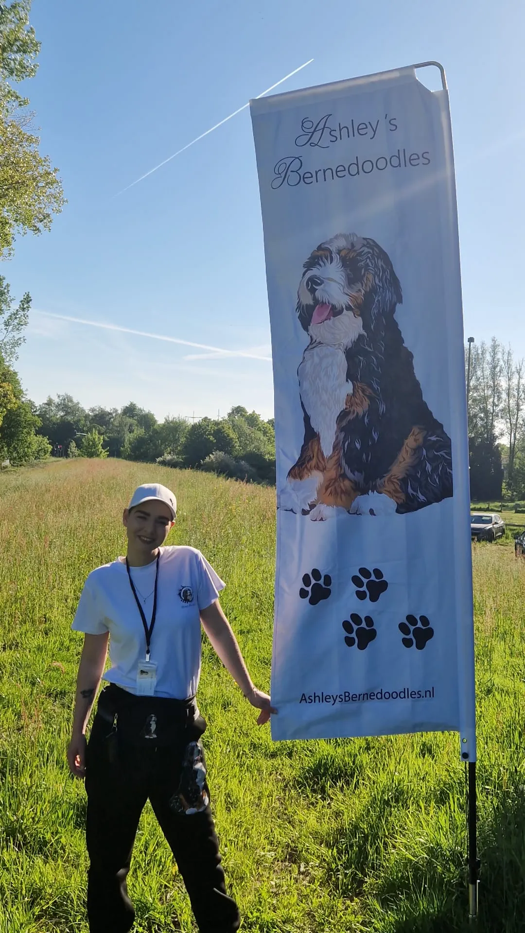 Ashley bij de beachvlag van Ashley's Bernedoodles